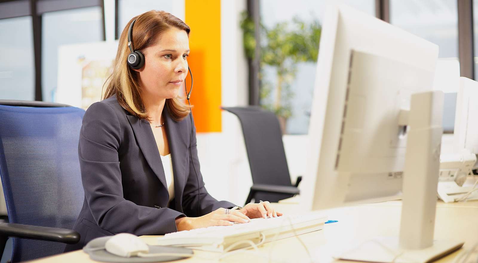 KVM-Mitarbeiterin im Gespräch am Computer